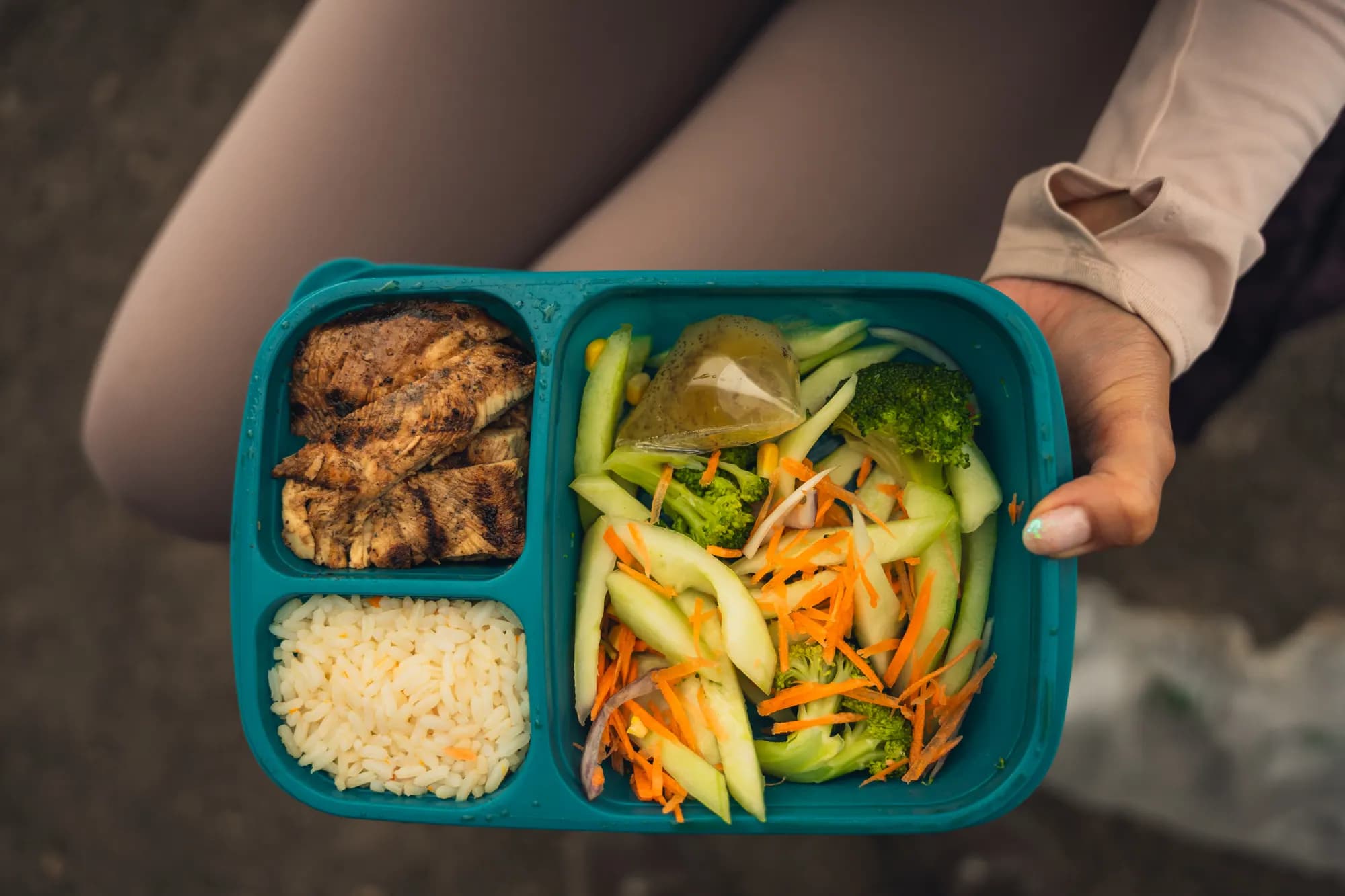 A packed mountain meal with chicken, rice and salad