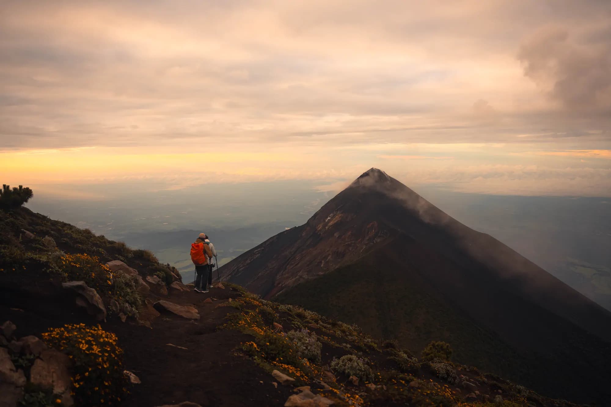 Small figures on the ridge below Fuego at dusk