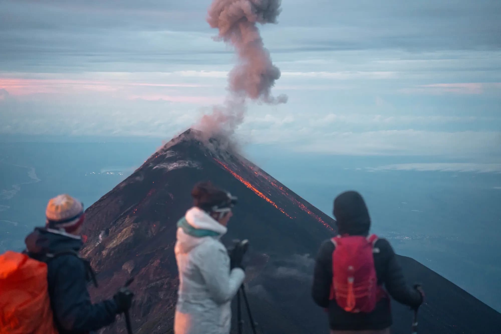 Travelers watching Volcán de Fuego release an ash column