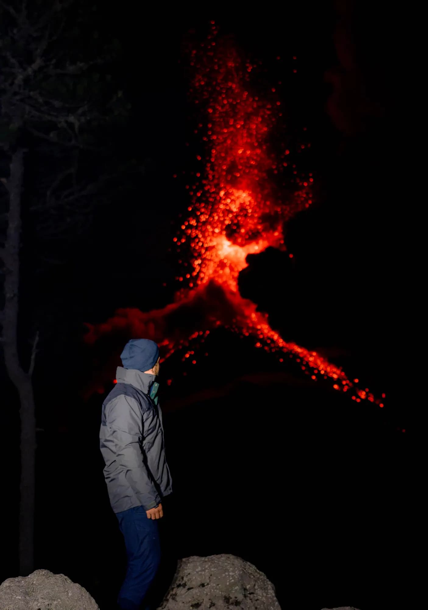 A traveler watching glowing lava on Fuego at night