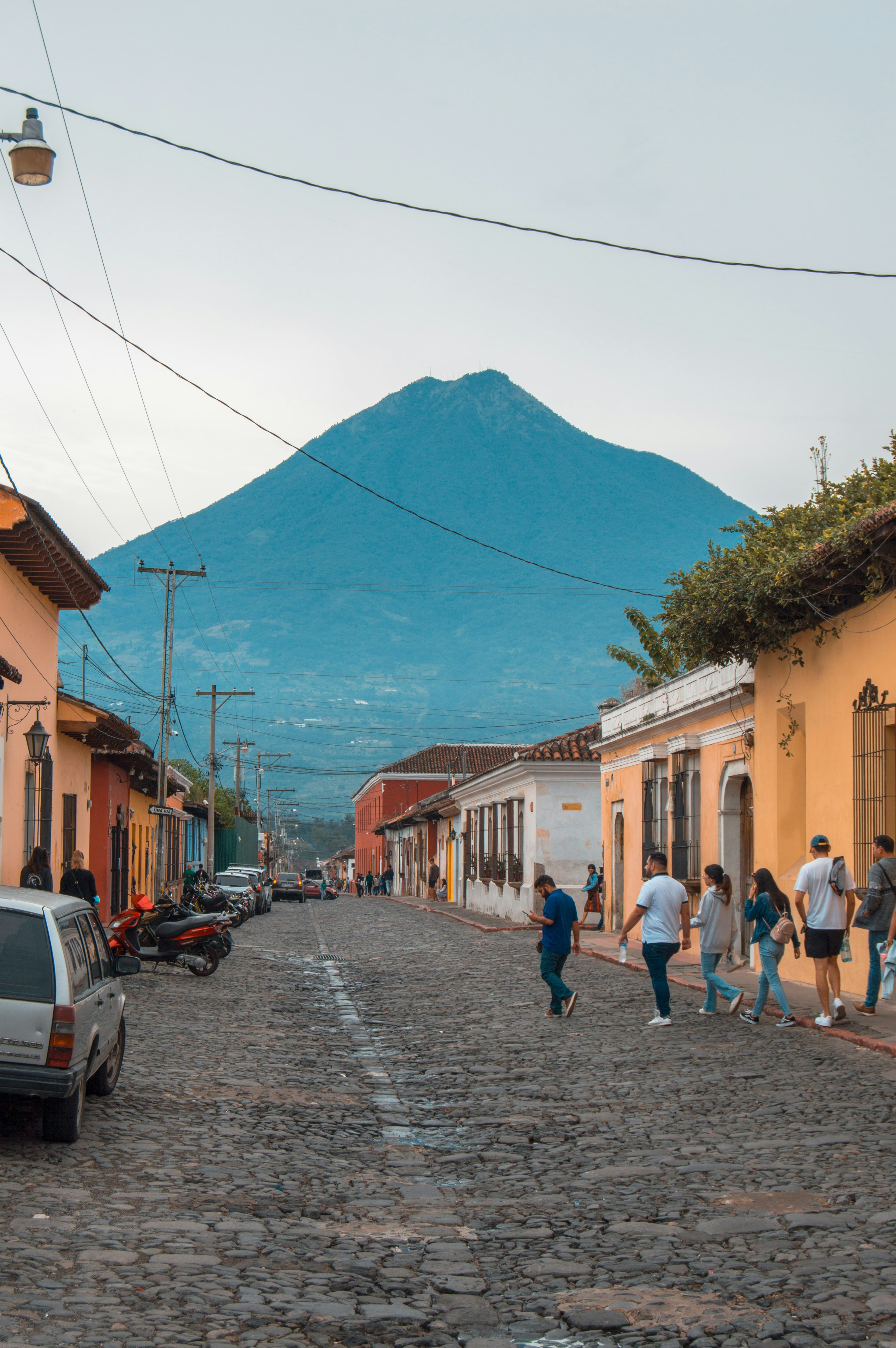 A local street in Antigua Guatemala with volcanoes in the distance